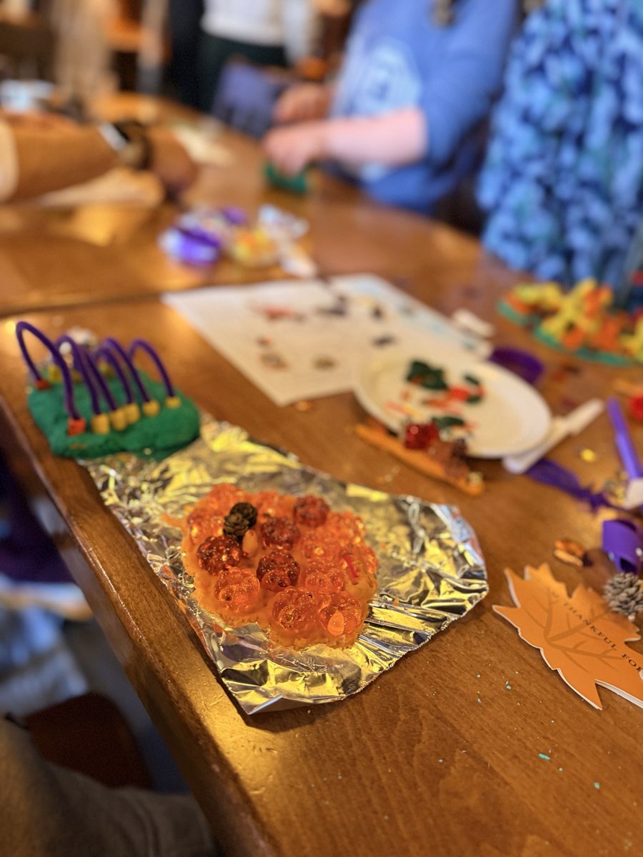 An orange playdough pumpkin patch covered in acrylic pumpkins and pinecones