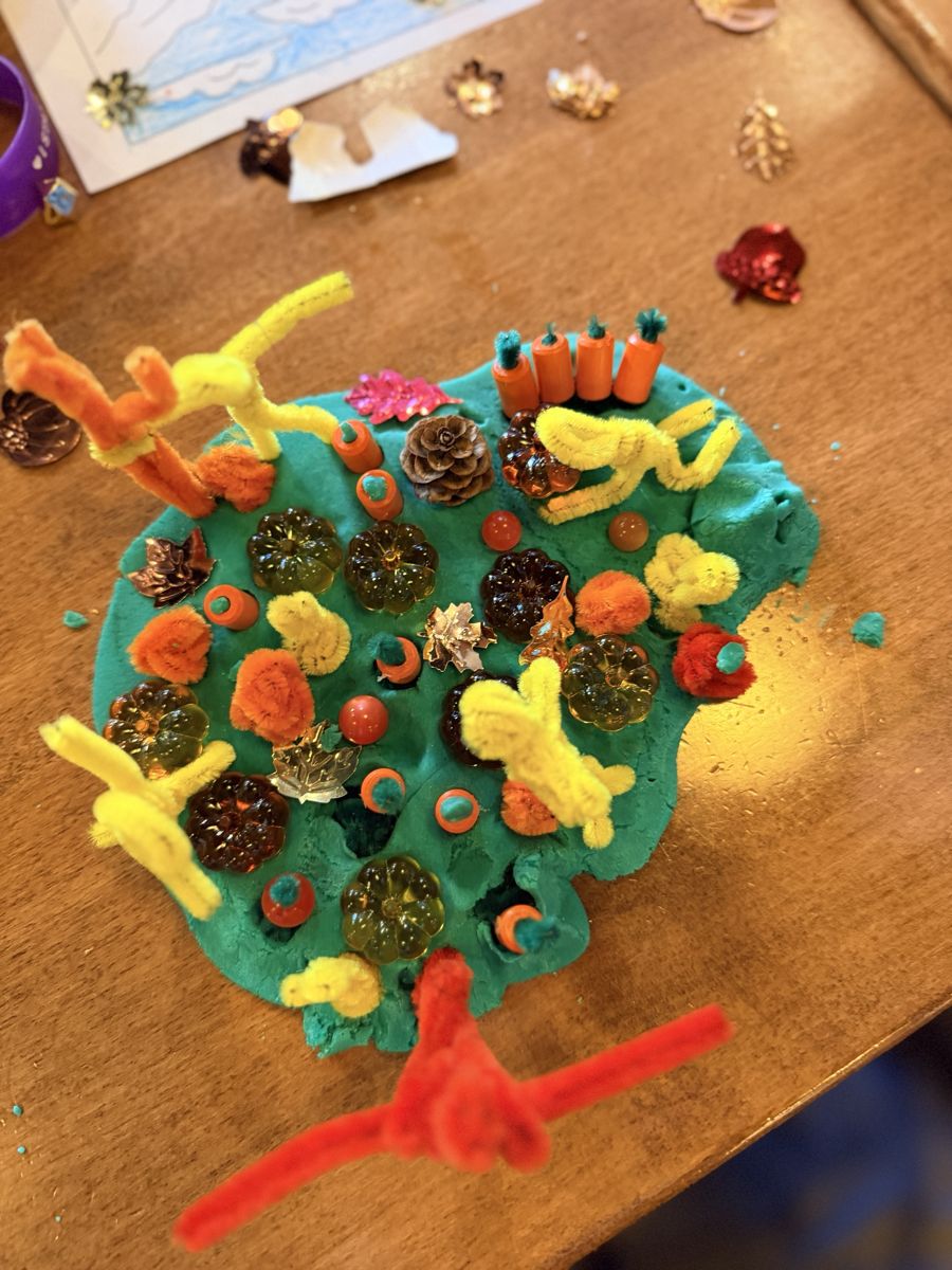 The massive playdough pumpkin patch from above, with acrylic pumpkins, pipe cleaner figures and wooden carrots