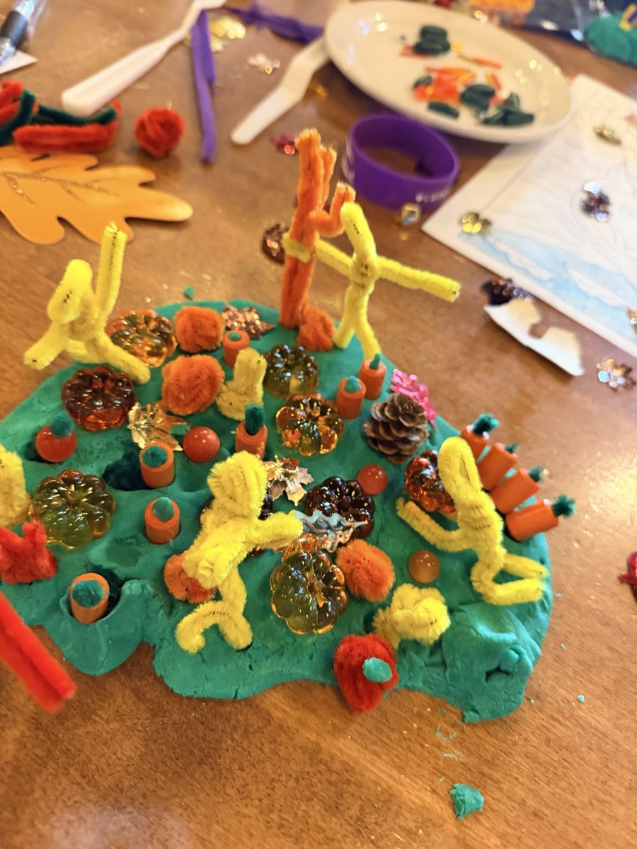 Close-up of the massive playdough pumpkin patch with yellow pipe cleaner people picking pumpkins